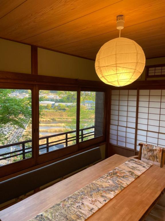 Habitación con mesa, lámpara y ventanas en えん吉野絶景広がる隠れ家1棟貸切ペットokサウナ室完備, en Yoshino