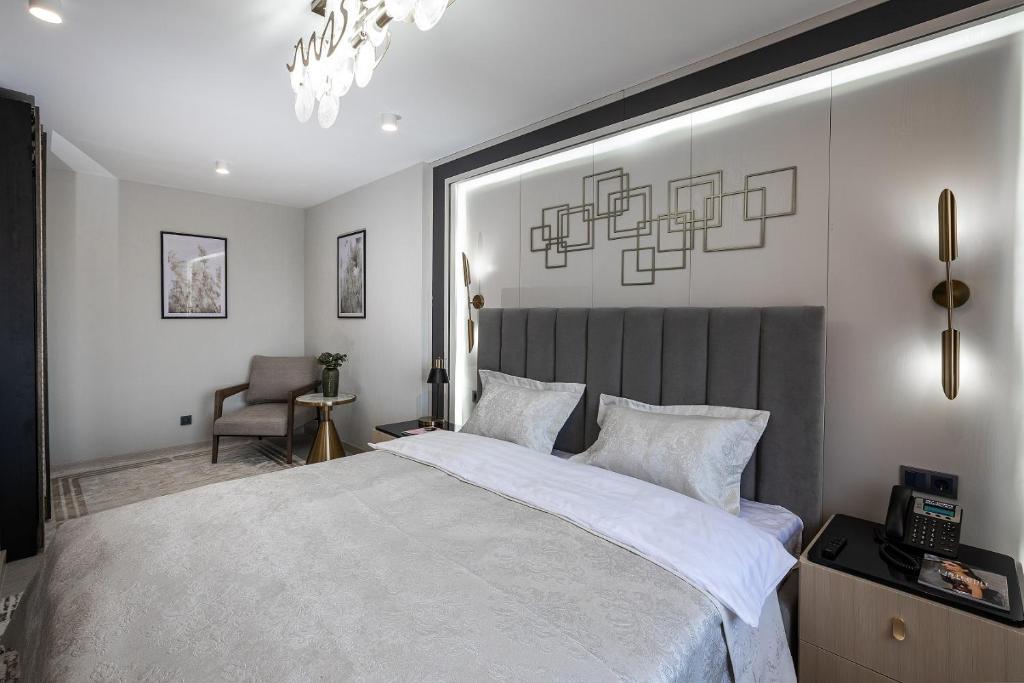 a bedroom with a large bed and a chair at Hotel Irtysh in Ustʼ-Kamenogorsk