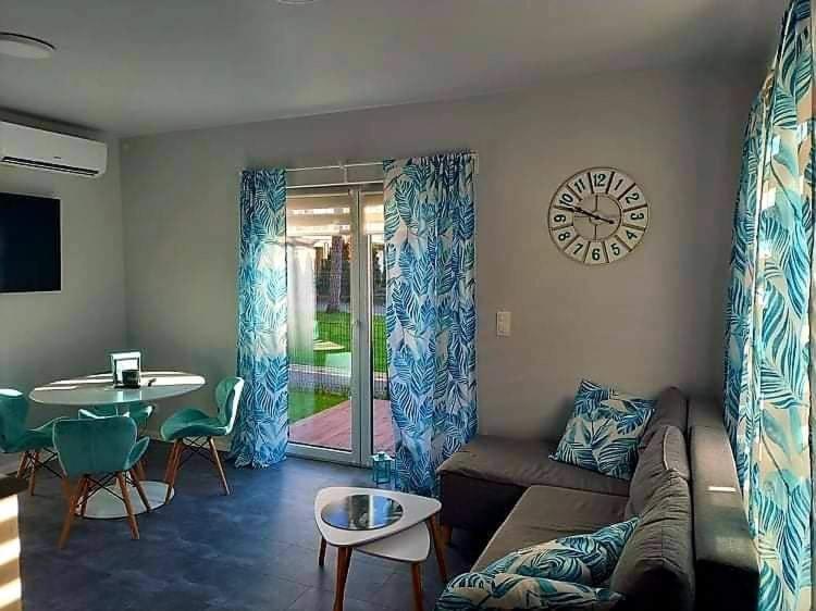 a living room with a couch and a clock on the wall at Horizon Park Carlo Rossi in Dziwnówek
