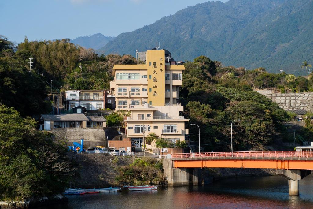 屋久島的住宿－屋久島山莊酒店，河岸边的一座建筑物,有一座桥梁