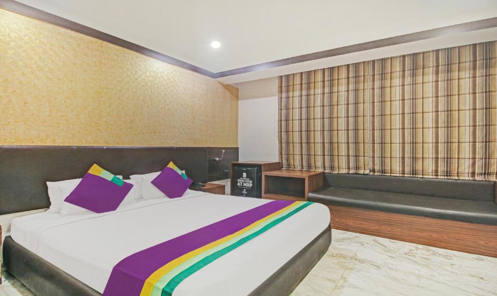 a bedroom with a bed with a rainbow blanket at Treebo Tryst Dee Empresa in Kolkata