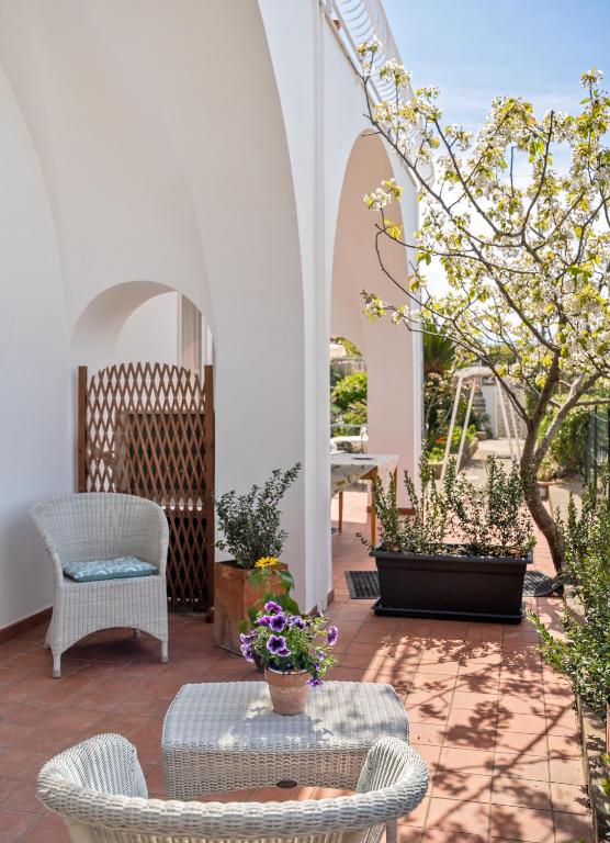a patio with two chairs and a table with flowers at B&B Il Sogno in Anacapri
