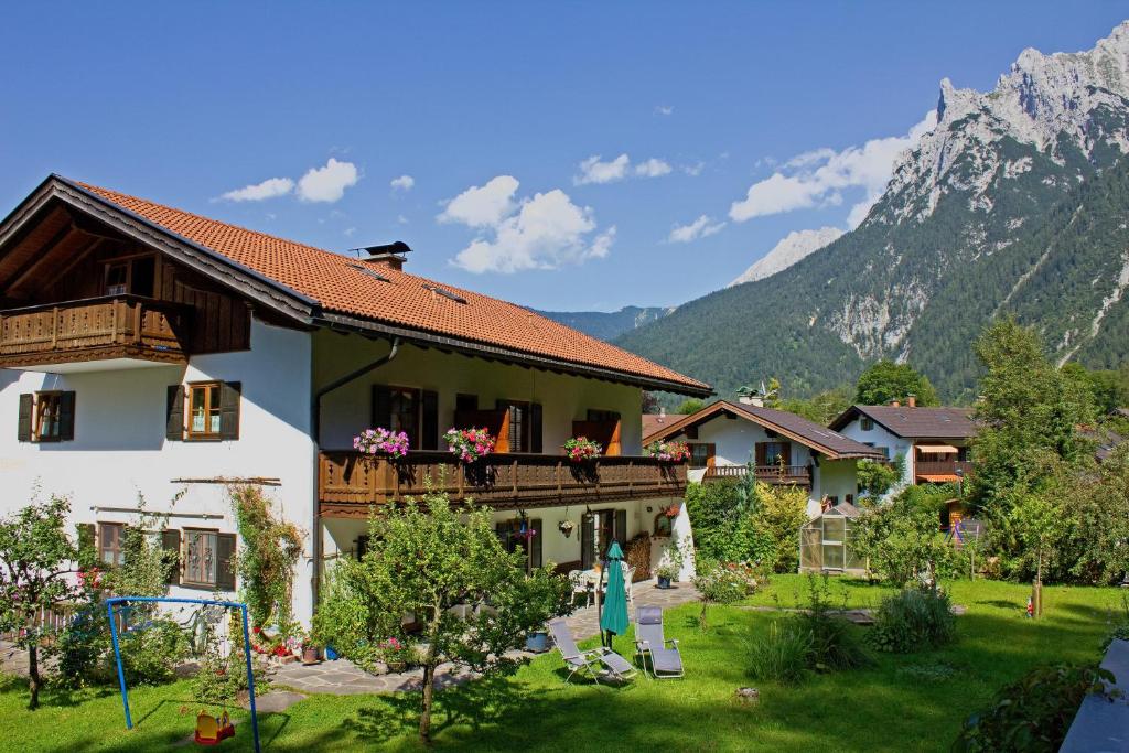 Casa con balcón con parque infantil y montañas en Gästehaus Kurparkfrieden, en Mittenwald