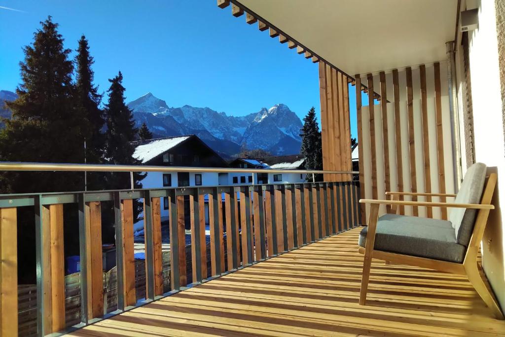 a balcony with a chair and a view of the mountains at LUNA Mountain Lodge Garmisch in Garmisch-Partenkirchen