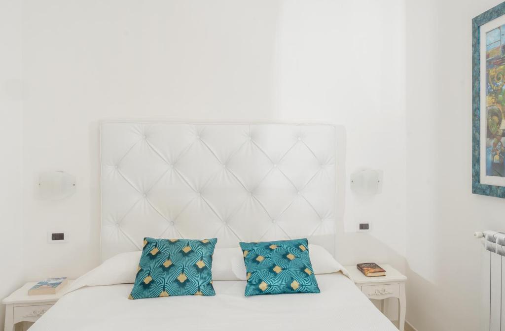 a bedroom with a white bed with blue pillows at B&B Il Sogno in Anacapri