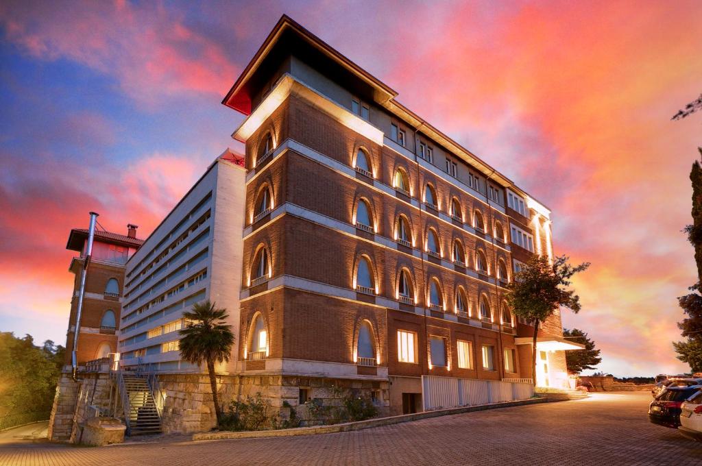 ein großes Gebäude mit farbenfrohem Himmel dahinter in der Unterkunft San Francesco Hotel in Loreto