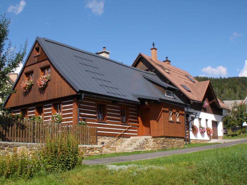 a wooden house with a black roof at Chalupa 409 in Rokytnice nad Jizerou