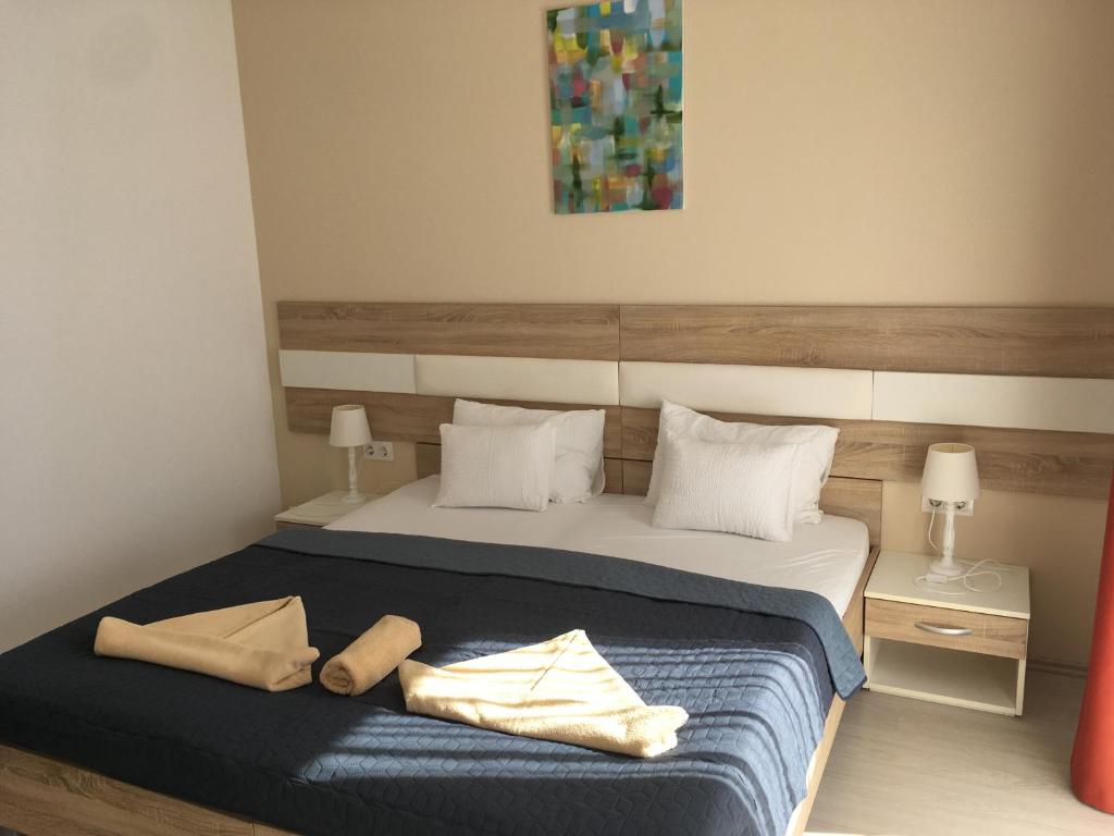 a bedroom with a large bed with a blue blanket at Hotel Pallone in Balatonfüred