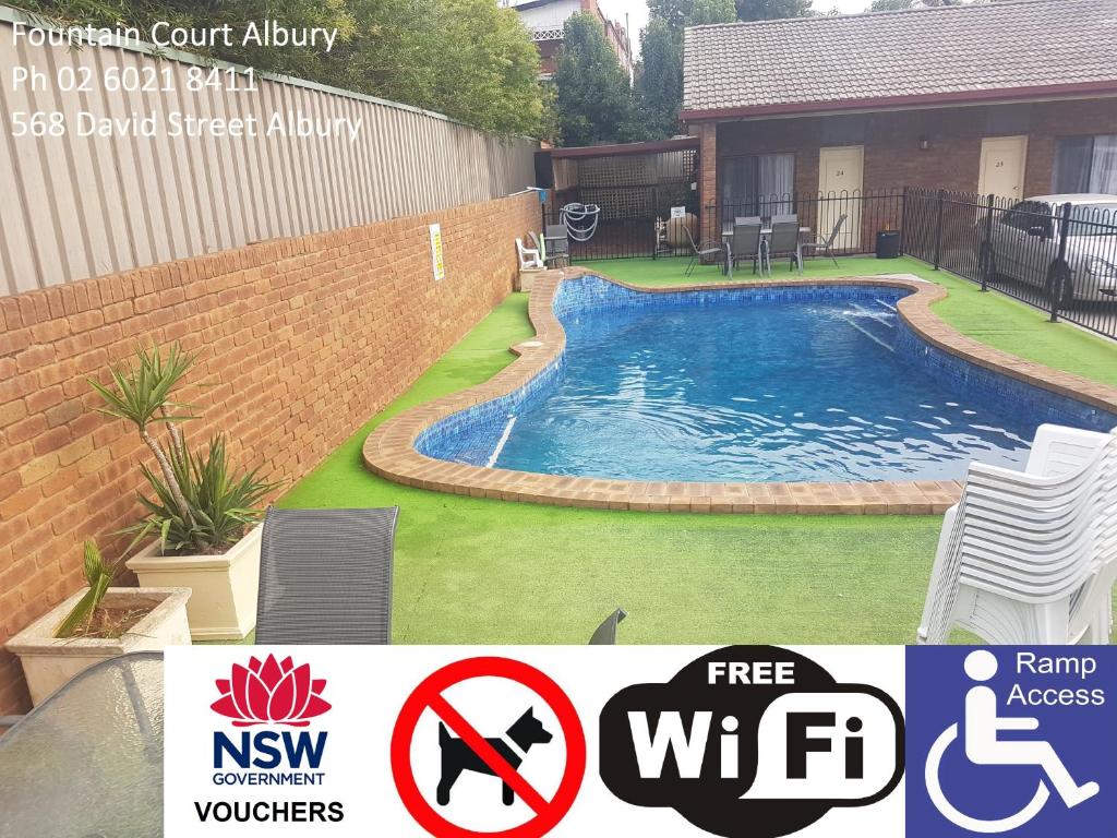 a swimming pool in a yard next to a house at Fountain Court Motor Inn Albury in Albury