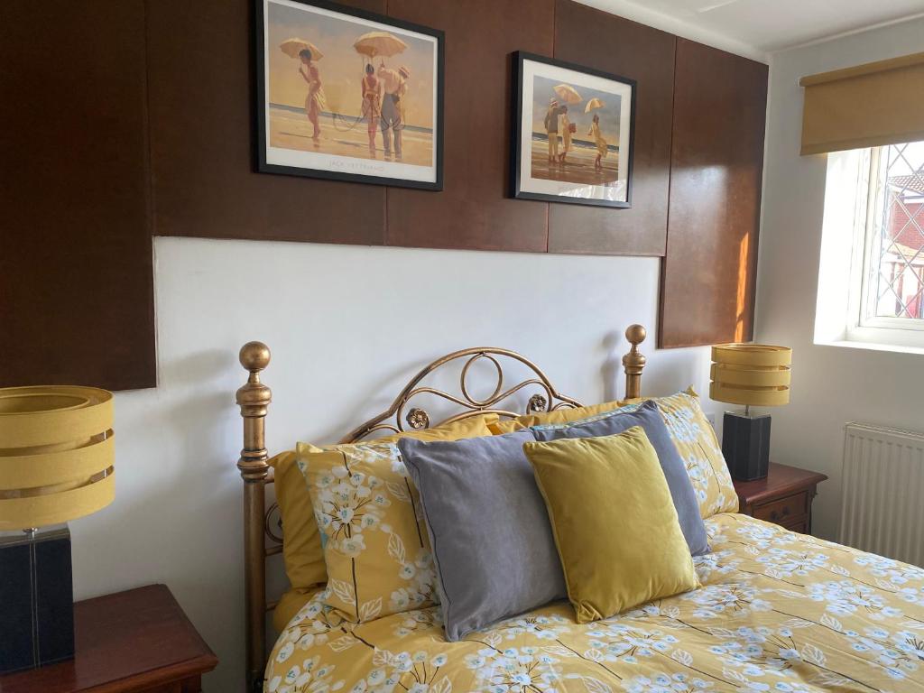 a bedroom with a bed with yellow and blue pillows at The Daytona - Triumph Apartments Meriden NEC 6.5m in Meriden