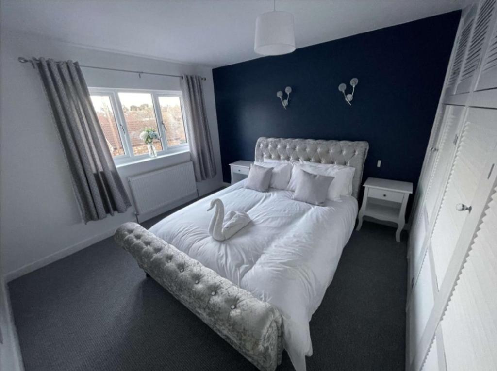 a bedroom with a large white bed with a bench on it at A beautiful house in a scenic town location. in Louth