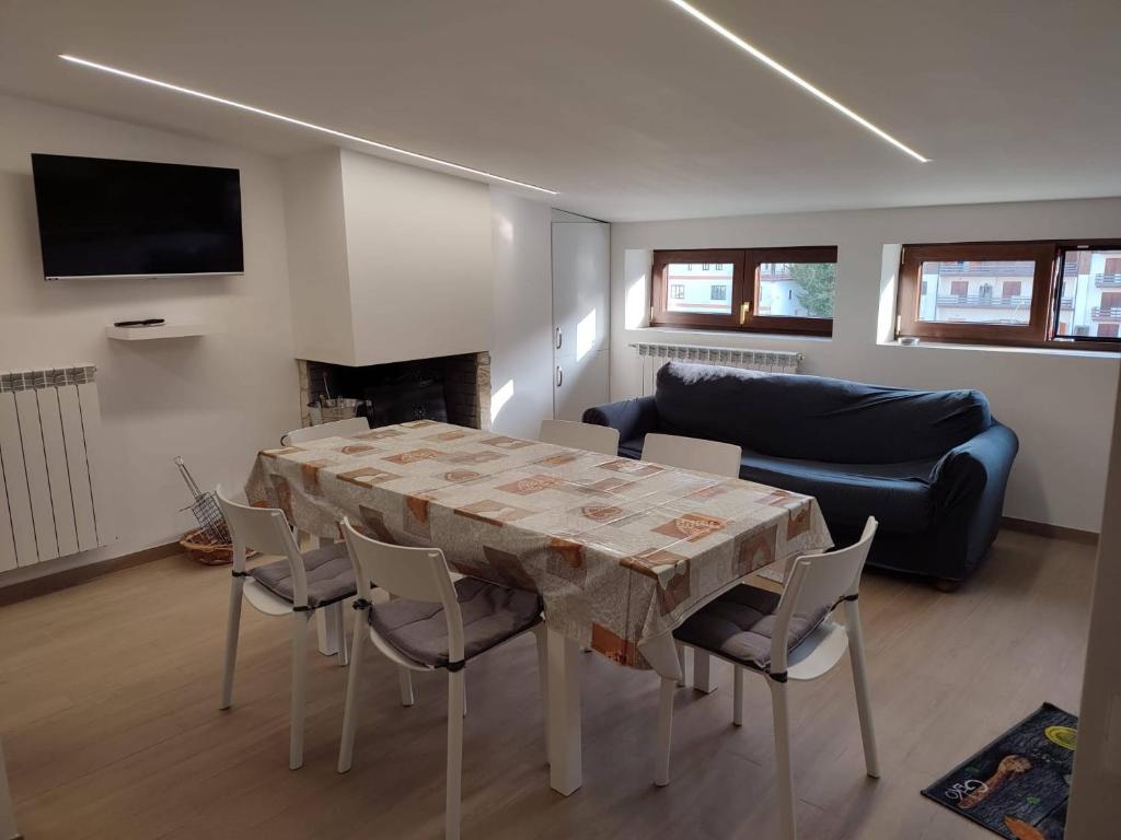 een woonkamer met een tafel en stoelen en een bank bij Residenze Macerelli in Roccaraso