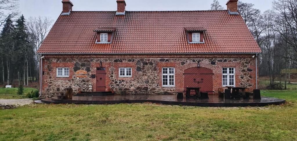 a large brick building with a red roof at Sepikoja Guest House in Alatskivi