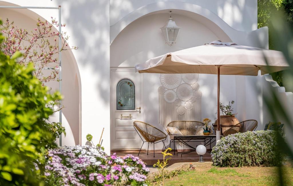 a patio with an umbrella and chairs and flowers at B&B Il Sogno in Anacapri