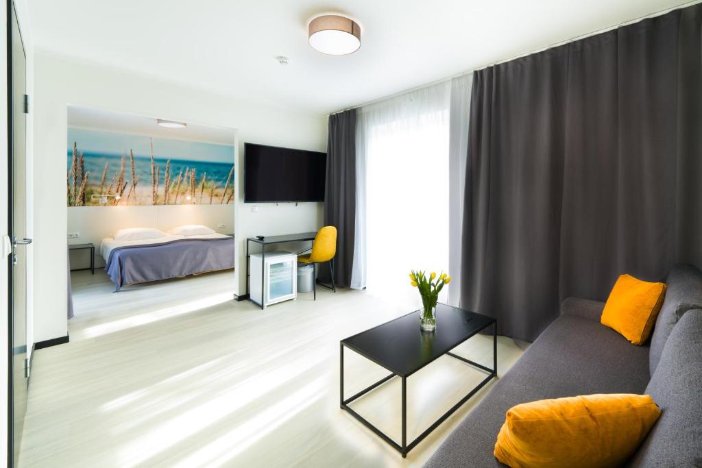 a living room with a couch and a bed at Hotel NOSPA in Kuressaare