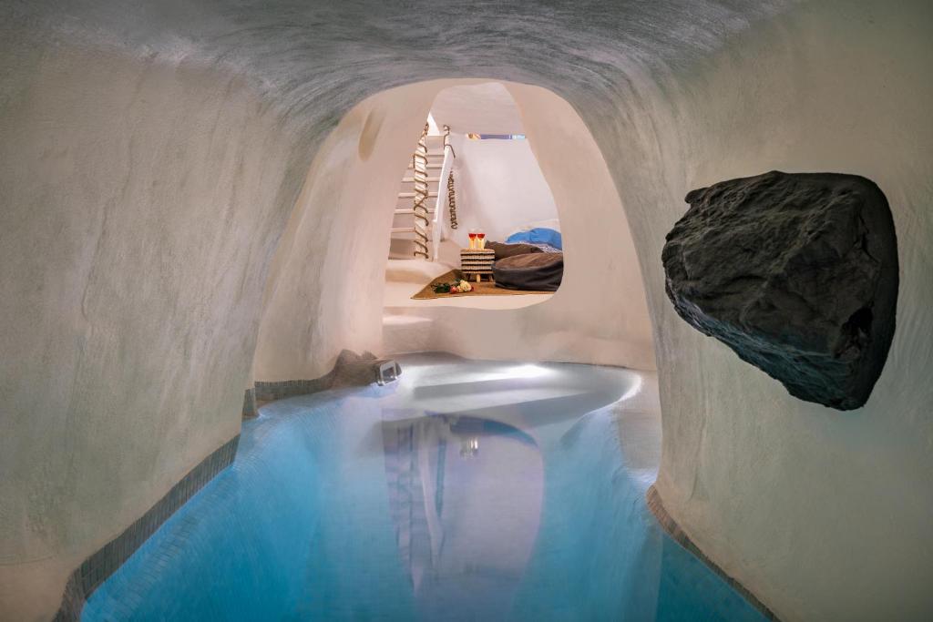 - une salle de bains avec une piscine d'eau dans une grotte dans l'établissement Mystagoge Retreat with subterranean pool/jacuzzi, à Vóthon