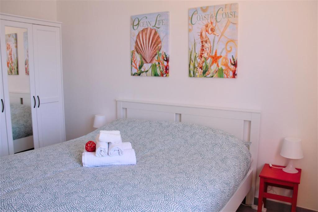 een slaapkamer met een bed met twee handdoeken erop bij Casa Luce Sabaudia in Sabaudia