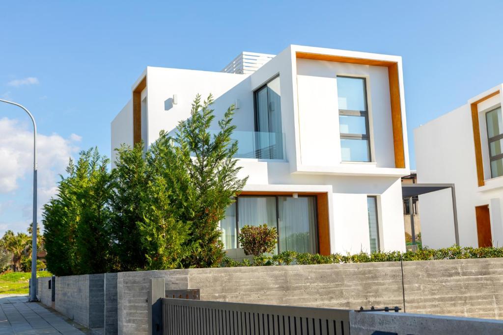 een wit huis met een hek ervoor bij Villa Laurus 2 with private pool in Paphos City