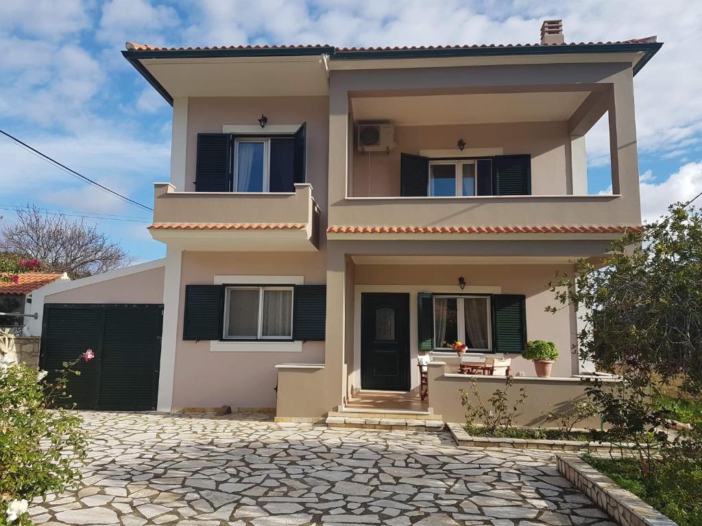 a white house with black shutters on it at Villa Andoni in Othonoi