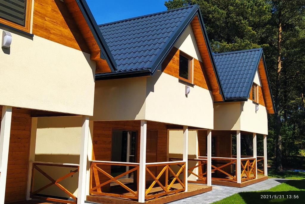 a house with a gambrel roof at BURSZTYNOWO Domy apartamentowe in Ostrowo