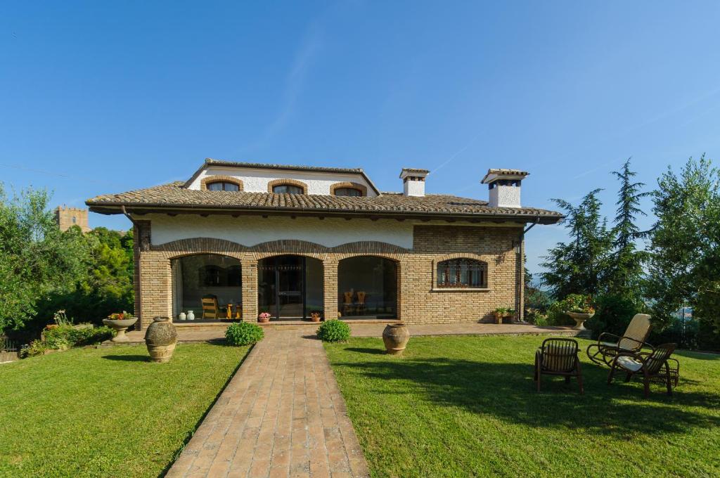 una gran casa de ladrillo con techo en el césped en Villa Mery sui colli della riviera di Rimini, en Mondaino