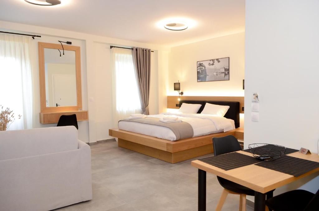 una camera da letto con un letto, una scrivania e un tavolo di Roloi suites a Nafpaktos