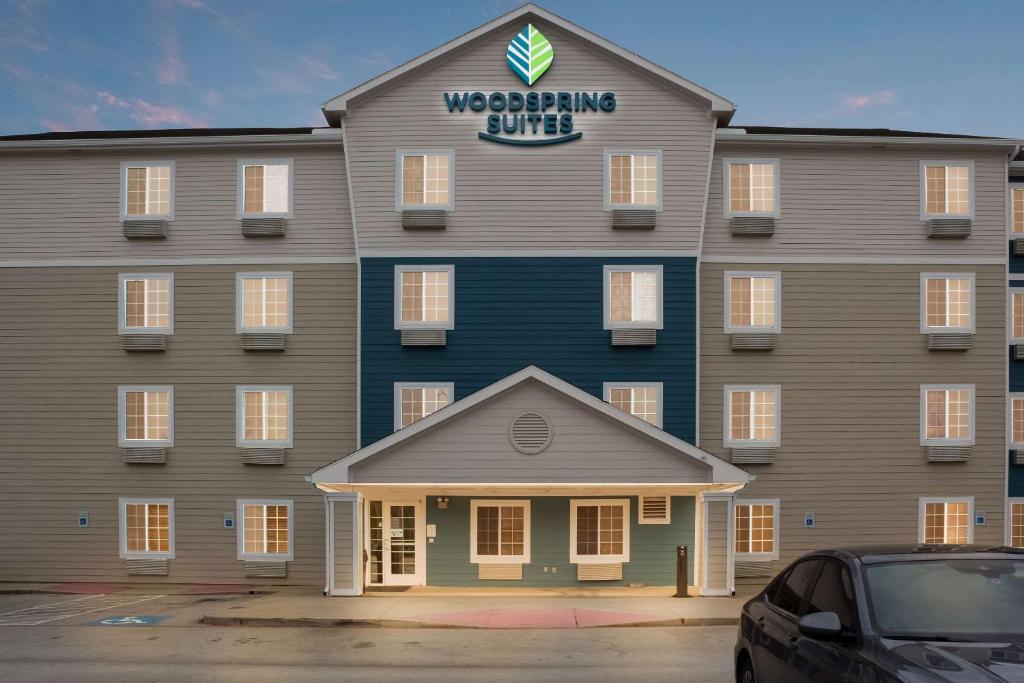 un gran edificio con un cartel en la parte delantera en WoodSpring Suites Conroe, en Conroe