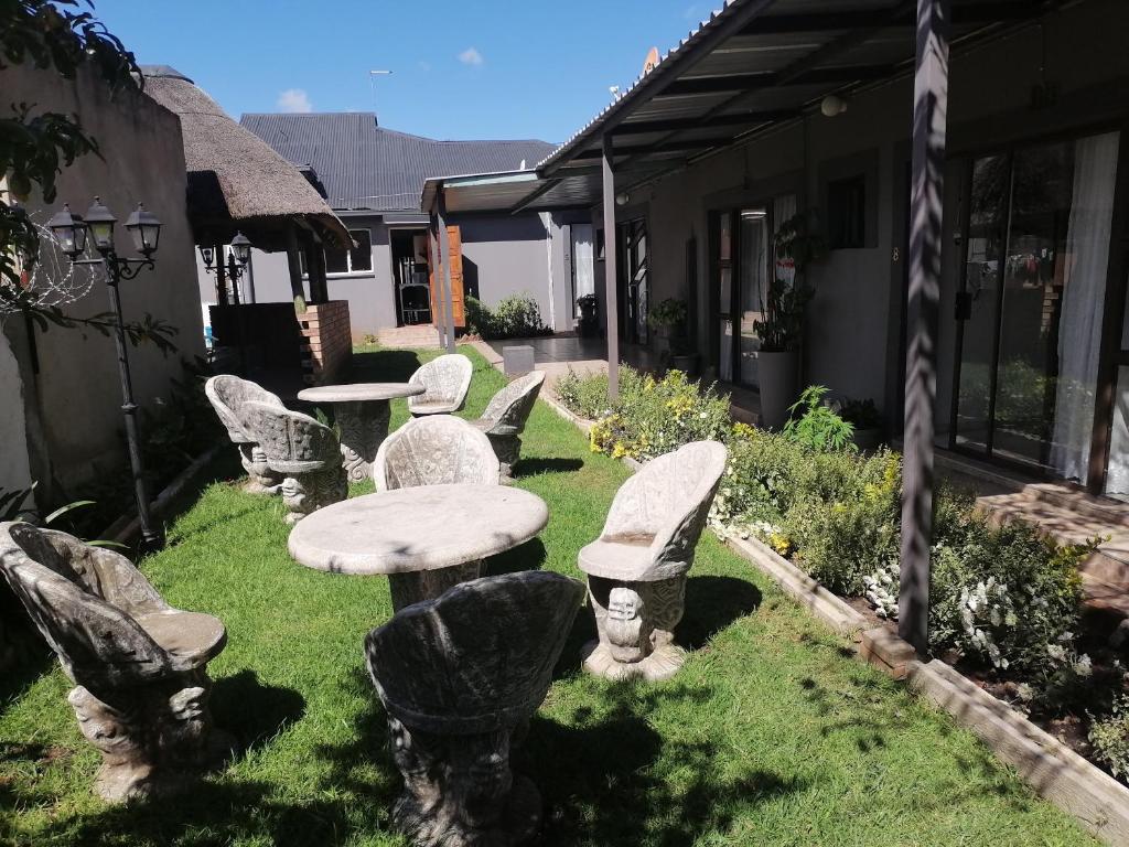 a group of chairs and a table in a yard at FRANCHISE BENONI GUEST HOUSE in Benoni