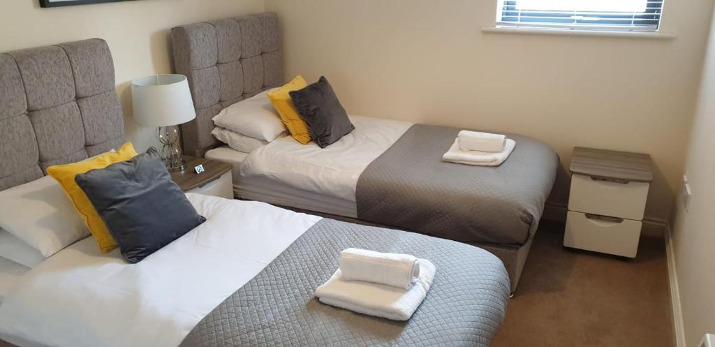 a small room with two beds with towels on them at BEST PRICE!Superb City Centre 2bd Apartment, 1 Double bed, 2 Singles or Superking, Sofabed, Smart TV & FREE SECURE PARKING in Southampton