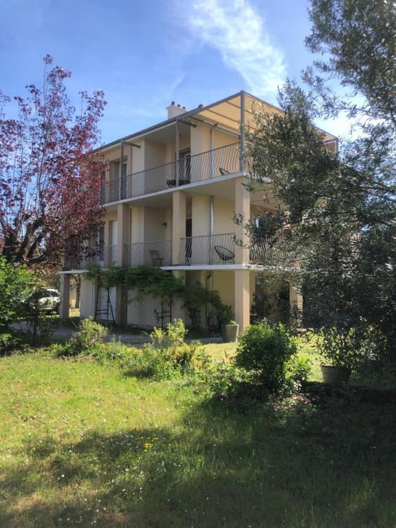 a large white building with a lot of trees at Condrieu appartement 1er in Condrieu