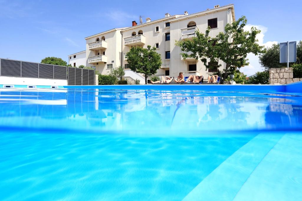 une grande piscine en face d'un bâtiment dans l'établissement Hotel Mediteran, à Zadar