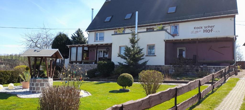 una gran casa blanca con un jardín delante de ella en Kockscher Hof, en Mittweida