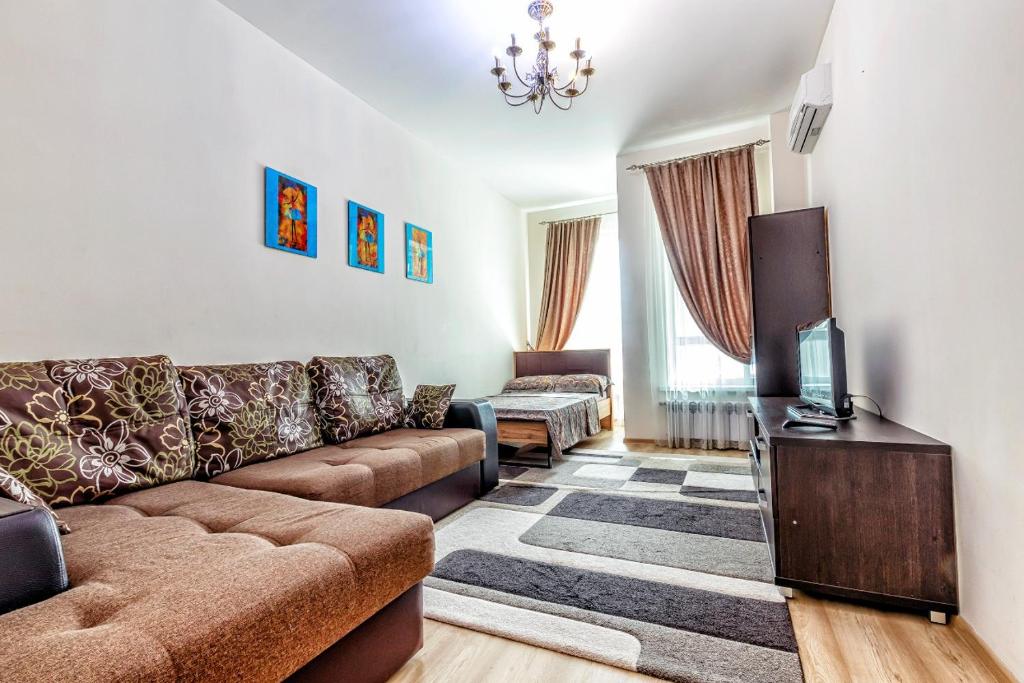 a living room with a couch and a tv at ЖК Expo Residence in Astana