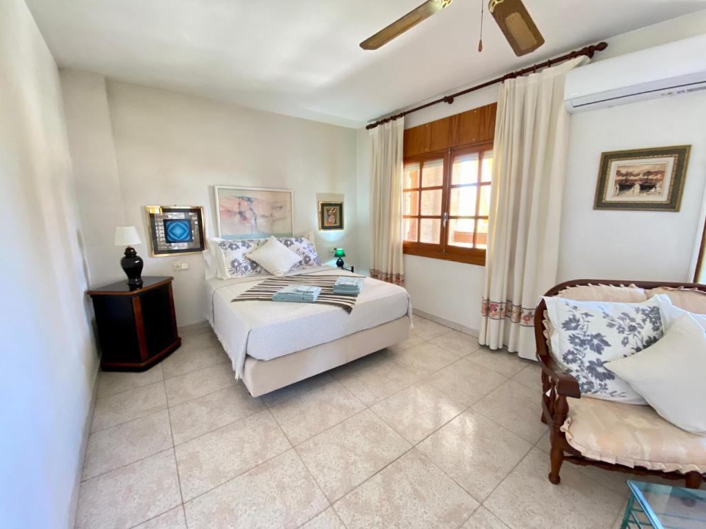 une chambre avec un lit et une chaise dans l'établissement Stunning 5 bed Villa La Font, private pool, à El Campello