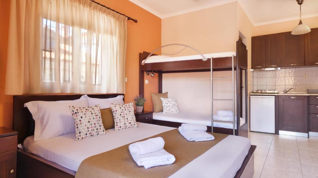 a bedroom with two bunk beds and a kitchen at House Chrysoula Mitsokopi in Sarti