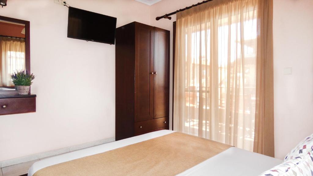 a bedroom with a bed and a large window at House Chrysoula Mitsokopi in Sarti