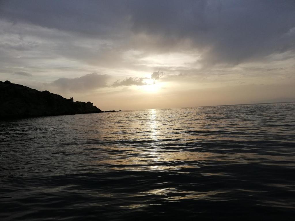 een zonsondergang boven het water met zonsondergang bij Apanemia 2 in Kinion