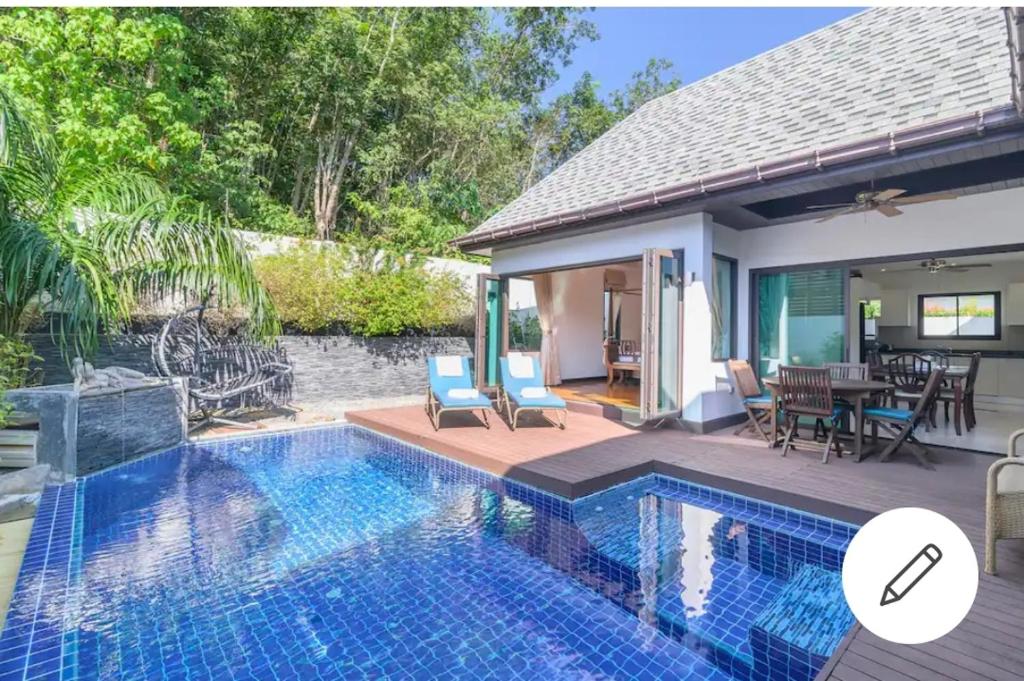 una villa con piscina y comedor en Naiharn Beach Villa, en Nai Harn Beach