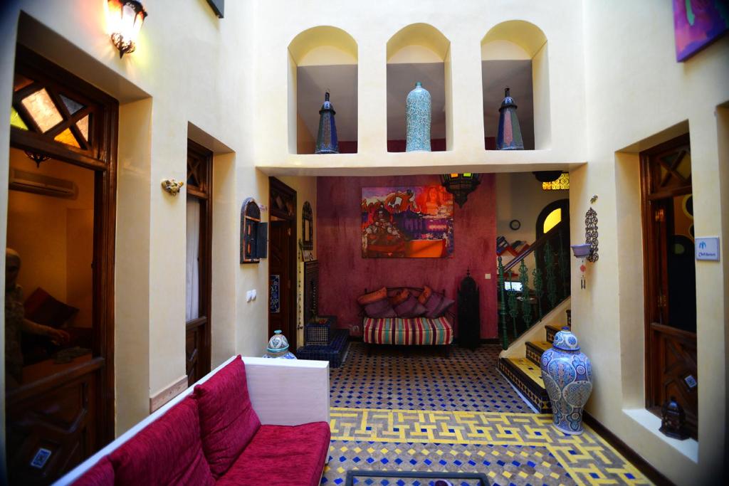 a living room with a red couch in a room at Riad Assilah in Asilah