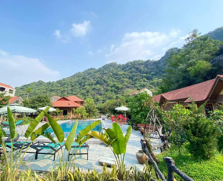 ein Resort mit Pool und Bergen im Hintergrund in der Unterkunft An Ngoc Tam Coc Bungalow in Ninh Bình