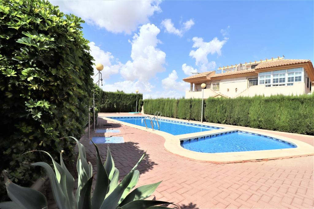 a swimming pool in front of a house at Ruidera Playa in Los Alcázares