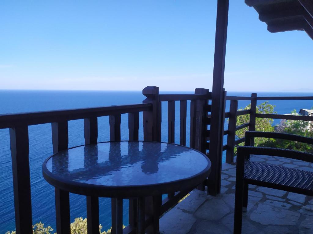 - stół i krzesła na balkonie z widokiem na ocean w obiekcie Triple studio room in Mylopotamos Beach w mieście Tsagarada