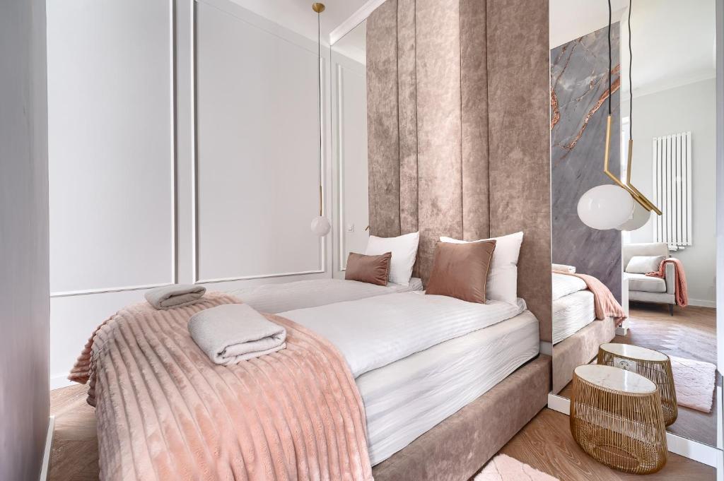 una camera da letto con un grande letto con lenzuola bianche di Apartament Aura LUX a Stettino