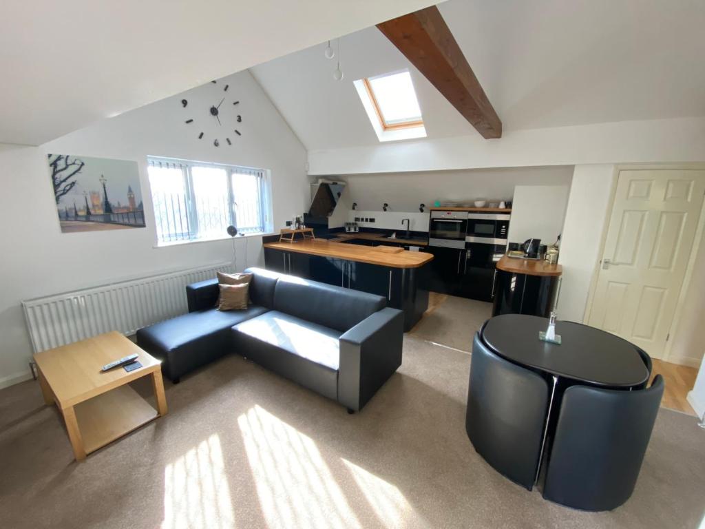 Il comprend un salon avec un canapé bleu et une cuisine. dans l'établissement Spacious One Bed Deluxe Apartment in Daventry, à Daventry