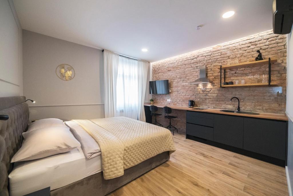 1 dormitorio con 1 cama, lavamanos y pared de ladrillo en Imperial Apartment P, 2nd Floor en Zagreb