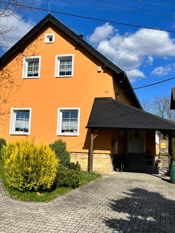 uma casa laranja com um telhado preto em Celý dům FLORA v Českosaském Švýcarsku em Janov