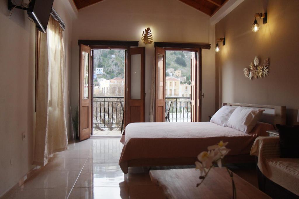 a bedroom with a bed and a couch and windows at Main square apartment in Symi