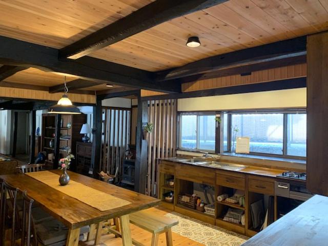 a living room with a table and some windows at Yakuno House in Fukuchiyama