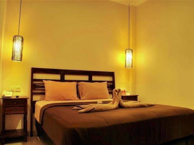 a bedroom with a large bed with two lights at Coco De Heaven House in Jimbaran