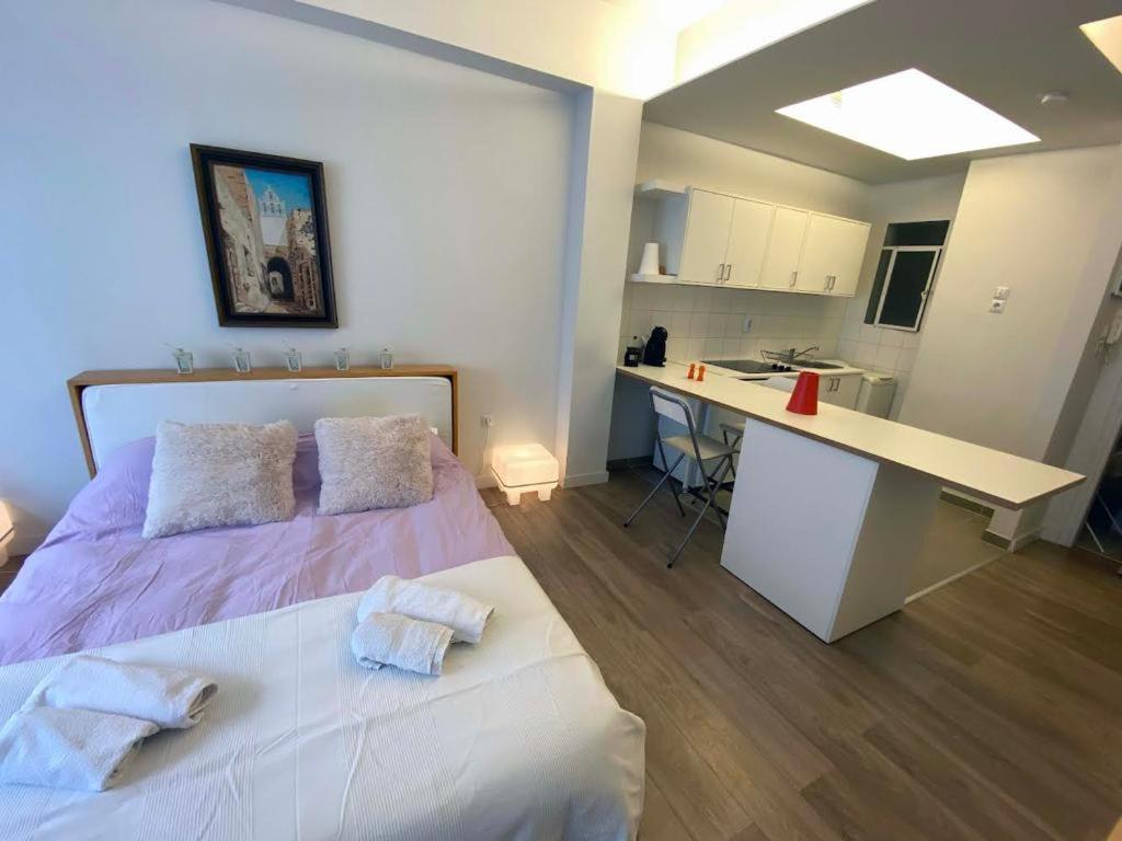 sypialnia z łóżkiem i biurkiem z ręcznikami w obiekcie Cozy Studio at Koukaki w Atenach